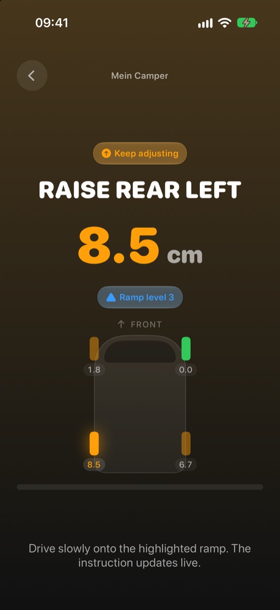 The levelling screen with the large instruction “Raise rear left”, 9.0 cm and a top-down view of the vehicle with the affected wheel highlighted.